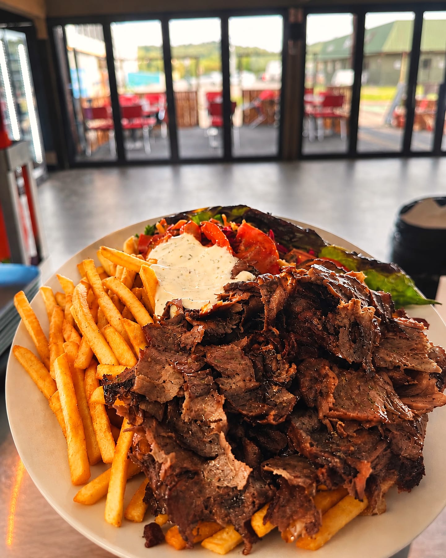 Dönerteller mit frisch geschnittenem Fleisch, Pommes, Salat und Sauce
