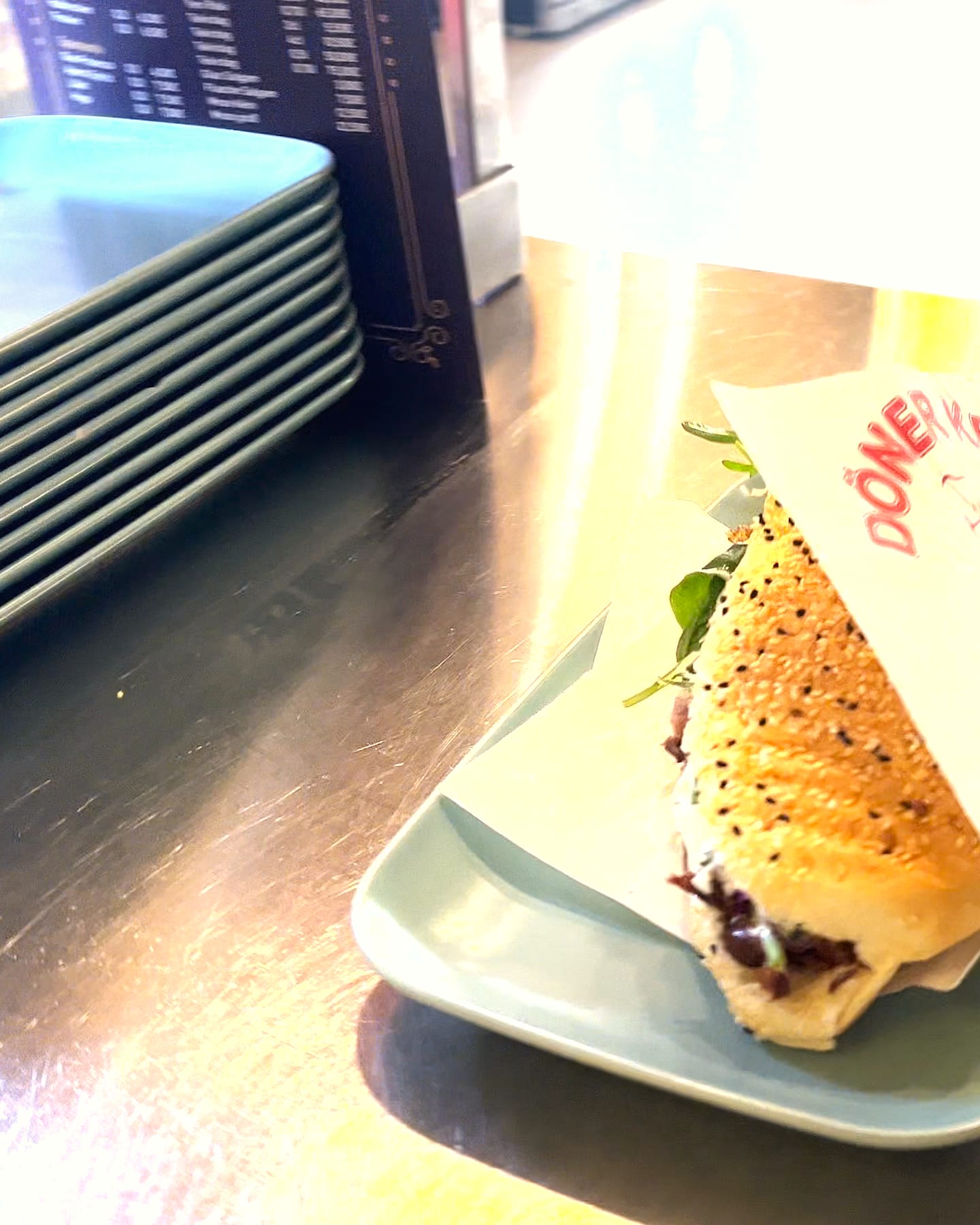 Fertiges Steak-Döner-Sandwich im Papier auf dem Tablett, bereit zum Mitnehmen